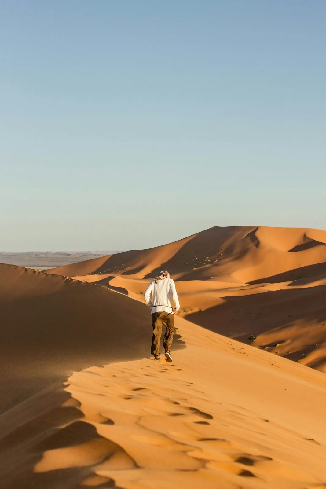 Viajero caminando solo entre las dunas del Sáhara