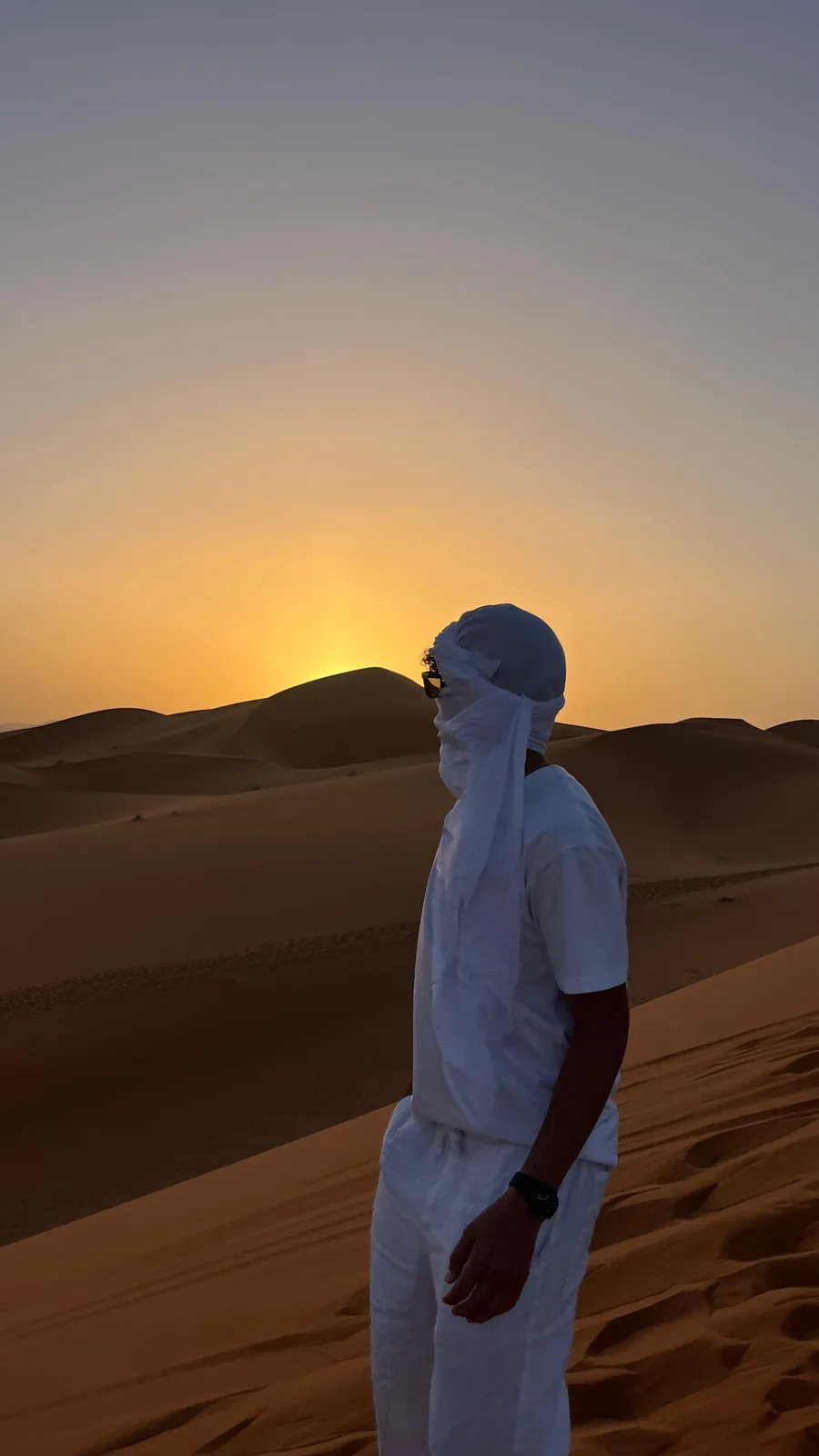 Viajero con turbante al atardecer en las dunas